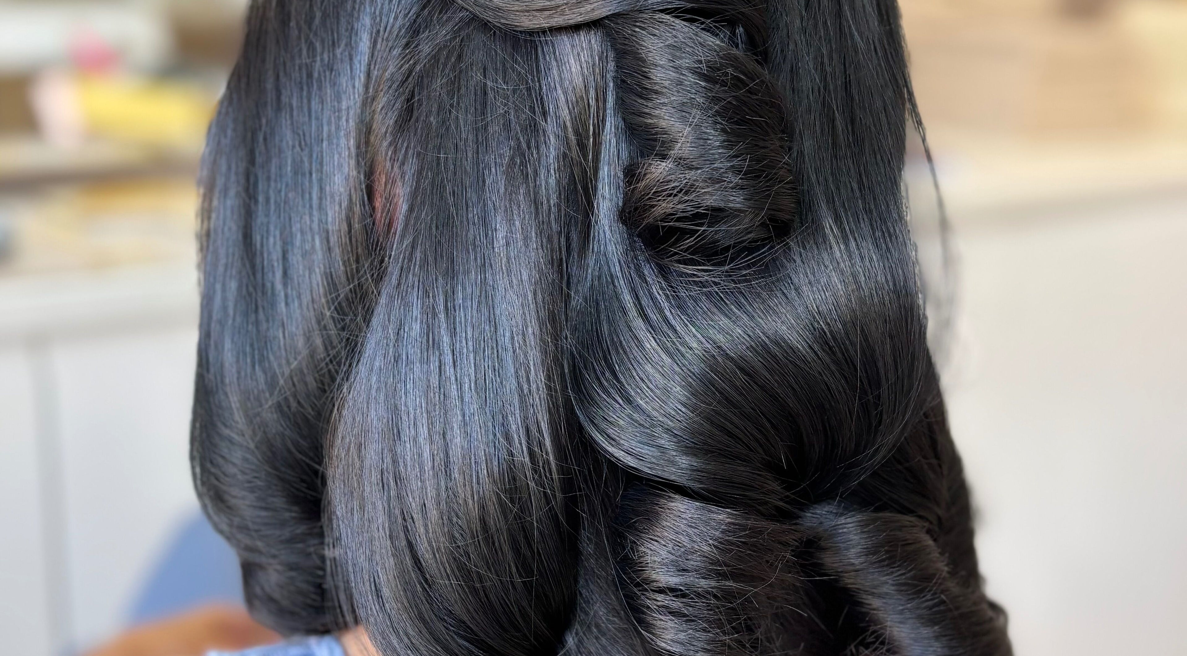 Sleek hairstyle with elegant curls at Bouncy Blowbar, Rochford, England, GB.