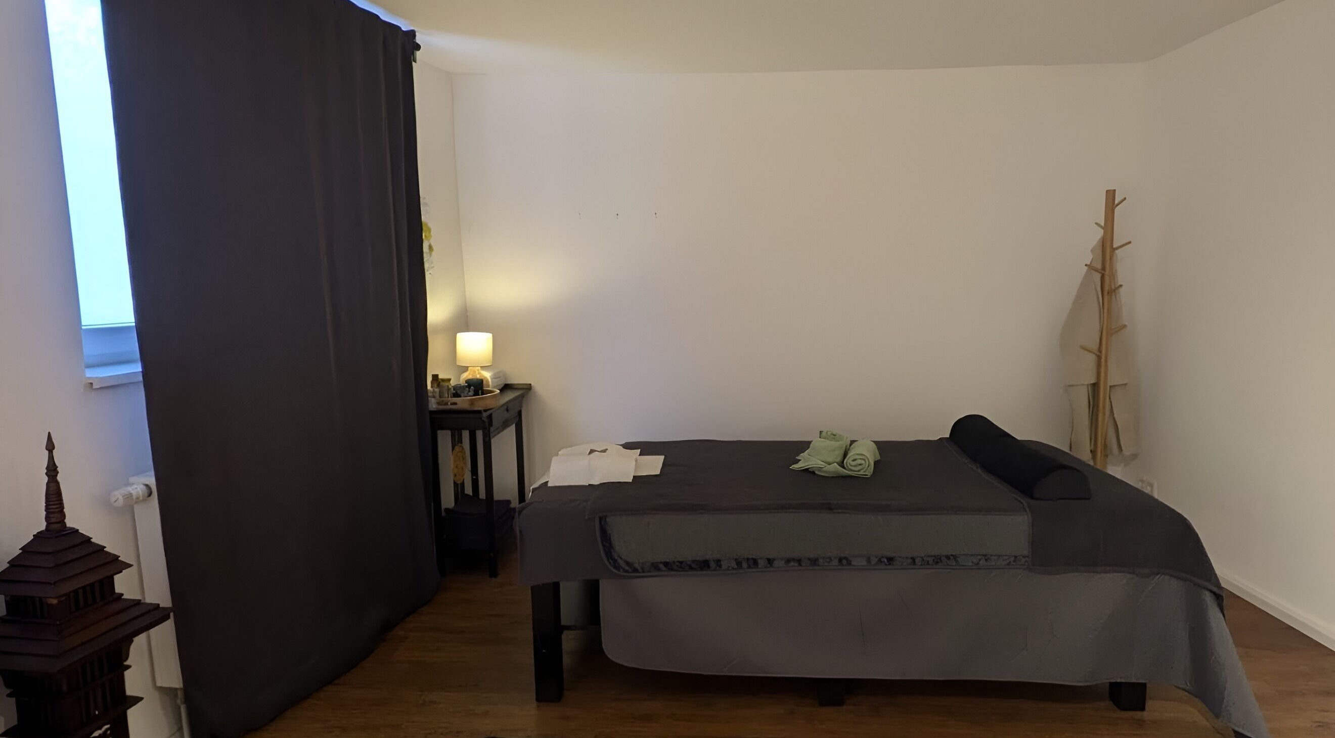 Ruheraum bei Baramie, Gau-algesheim, Rheinland-pfalz, DE mit Massagebett und sanfter Beleuchtung.