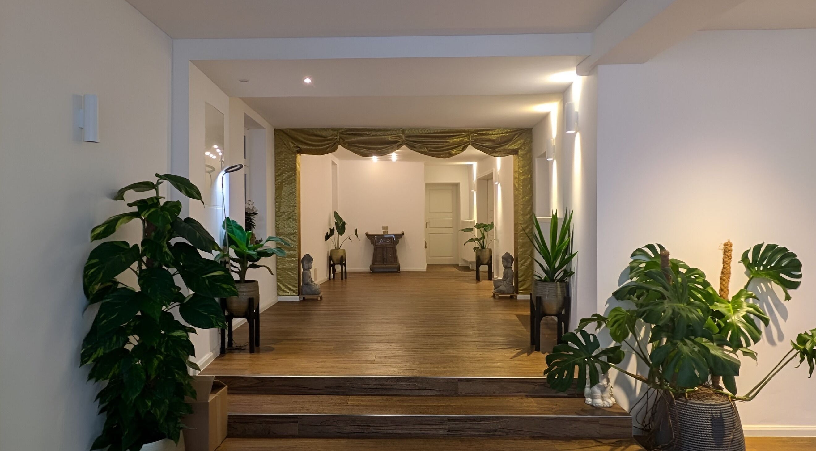 Eingangsbereich von Baramie, Gau-algesheim, Rheinland-pfalz, DE mit Pflanzen und Buddha-Statuen.