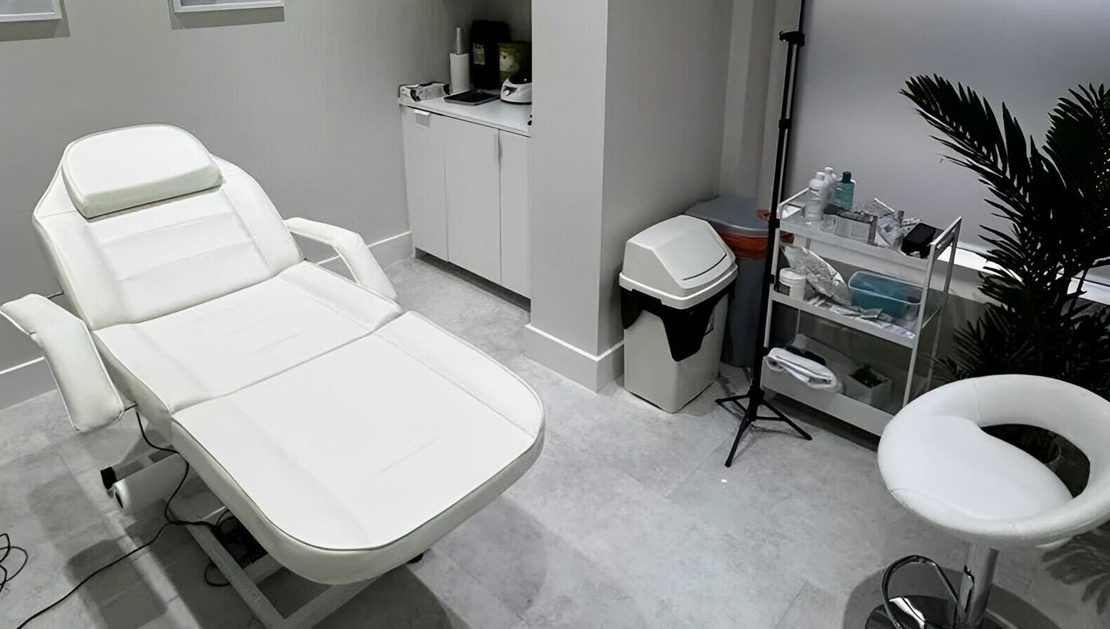 Modern treatment room at CLINICBYSALMA, London, England. Featuring comfy chair and sleek equipment.