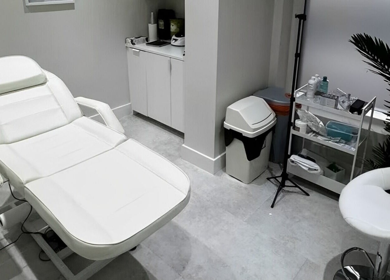 Modern treatment room at CLINICBYSALMA, London, England. Featuring comfy chair and sleek equipment.