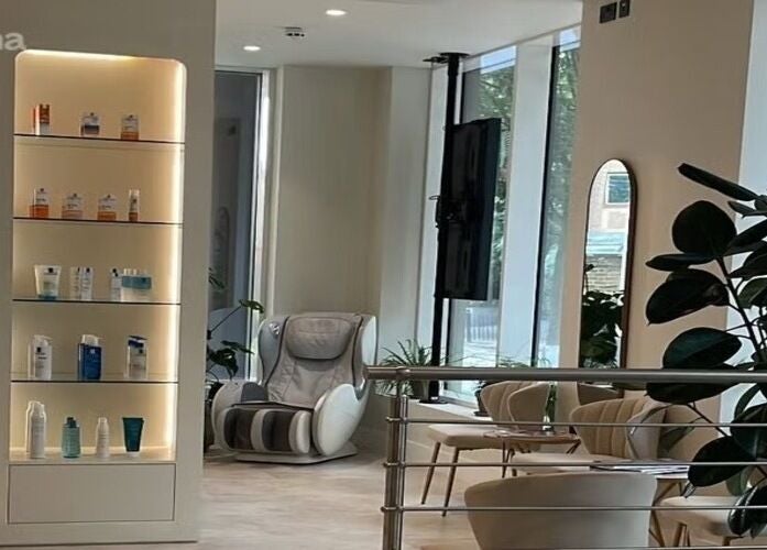 Elegant relaxation area at CLINICBYSALMA, featuring massage chair and product display in London, England, GB.