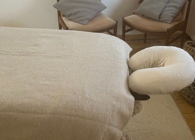 Massage table at Faelt, a serene wellness venue in Birmingham, England, GB, with cozy chairs and natural decor.