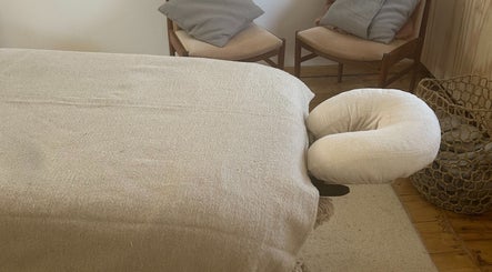 Massage table at Faelt, a serene wellness venue in Birmingham, England, GB, with cozy chairs and natural decor.