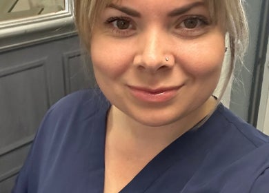 Friendly staff member at Nikki Porter FHP, Birmingham, England, GB in a welcoming blue uniform.