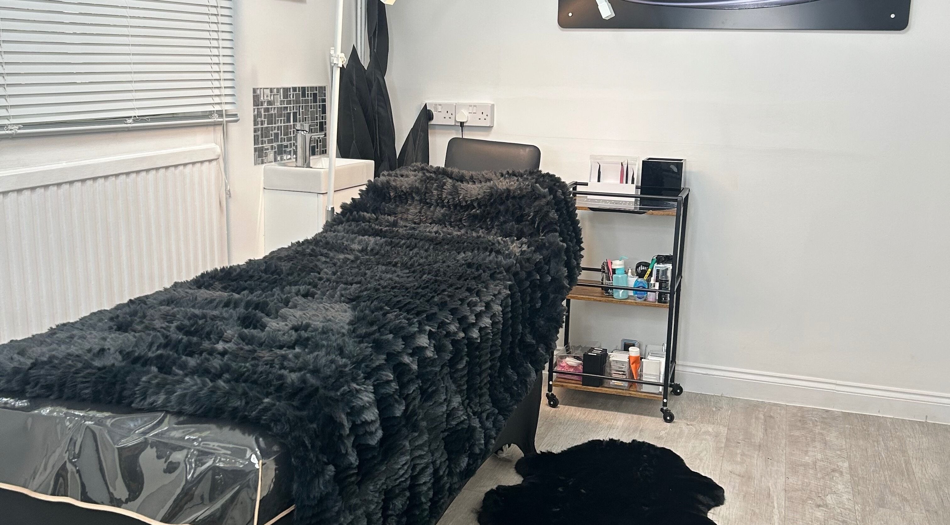 Comfortable treatment room at Halo Beauty Hatfield, Hatfield, England, GB, featuring a plush bed and modern decor.