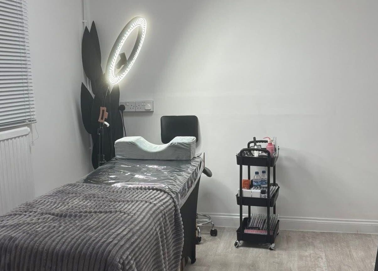 Treatment room at Halo Beauty Hatfield, Hatfield, England, GB with a table, chair, and skincare cart.