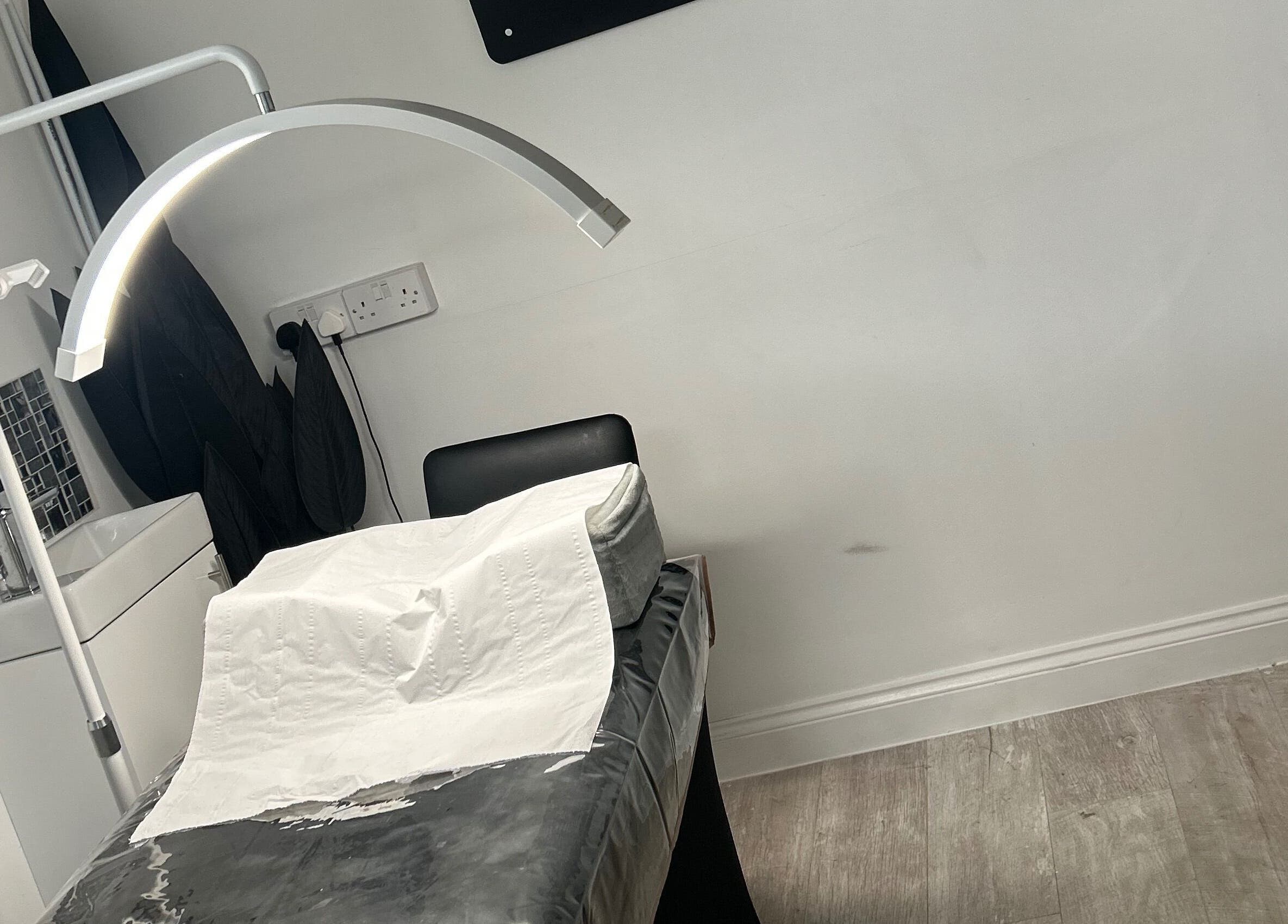 Relaxing treatment room at Halo Beauty Hatfield in Hatfield, England, GB with a cozy chair and modern lighting.