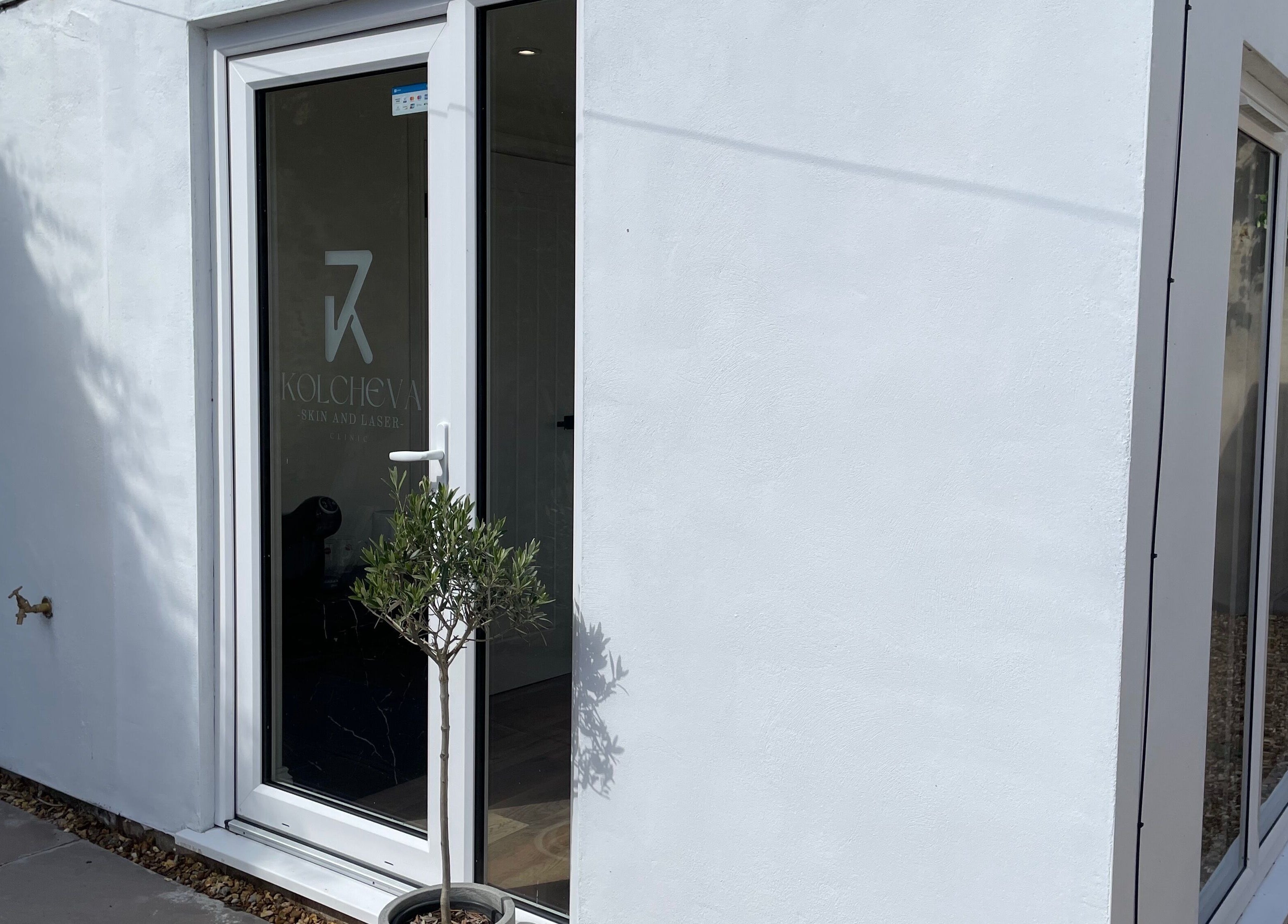 Elegant exterior of Kolcheva Skin & Laser Clinic in Kirkham, England, GB, showcasing modern glass door entry.
