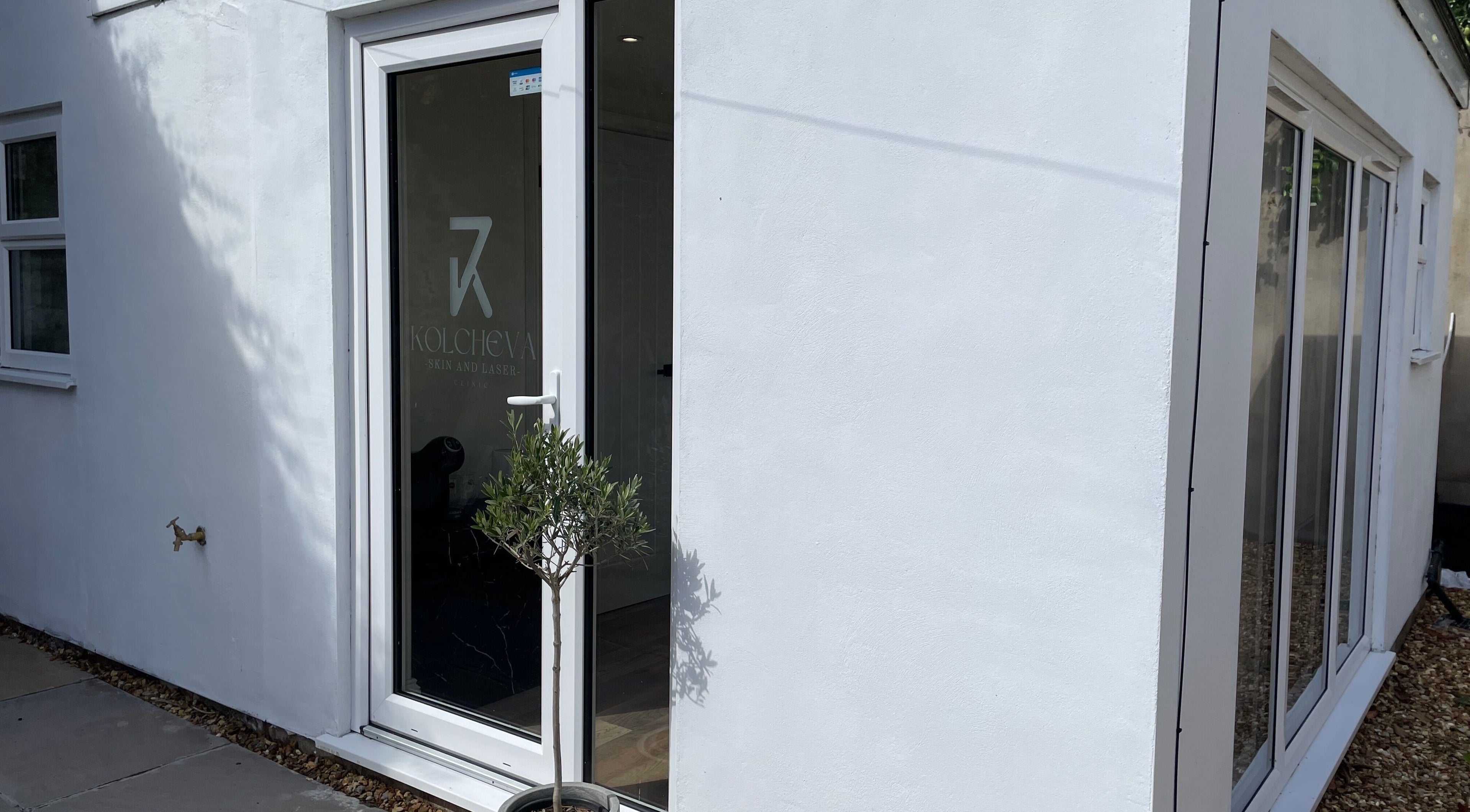 Elegant exterior of Kolcheva Skin & Laser Clinic in Kirkham, England, GB, showcasing modern glass door entry.