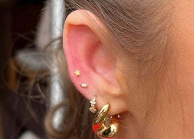 Elegant ear piercings showcasing gold jewelry at The beauty shack @ muse studio, Longwell Green, England, GB.