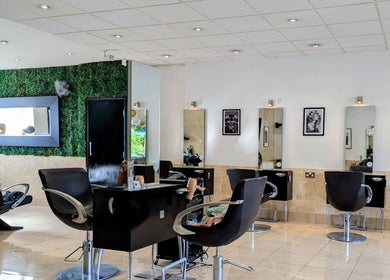 Modern salon interior at Bex at Lillywhite & Co., Wakefield, England, GB with stylish black chairs and green decor.