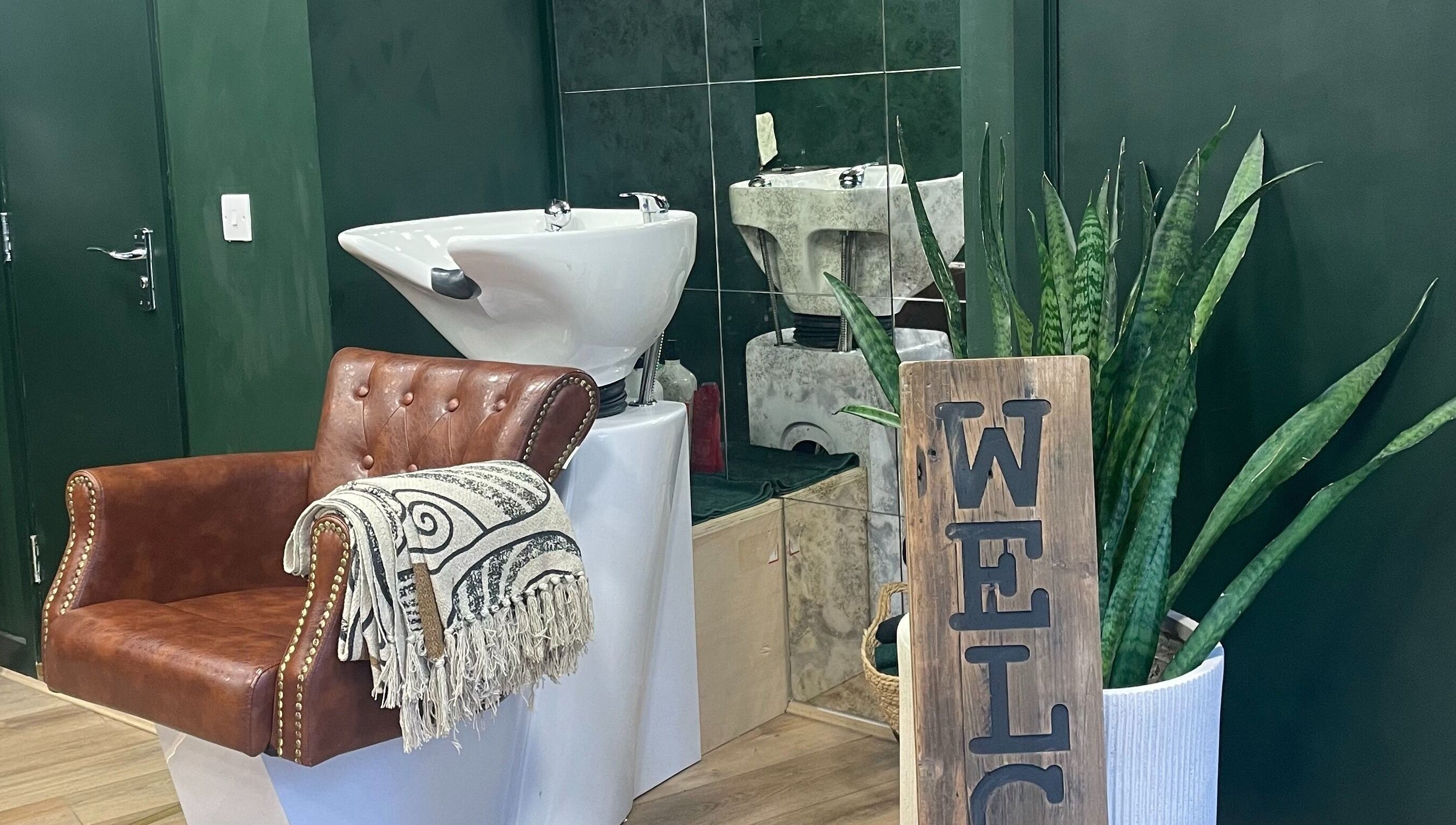 Inviting salon space at Koko - Emma, Cirencester, England, GB with elegant chair and lush greenery.