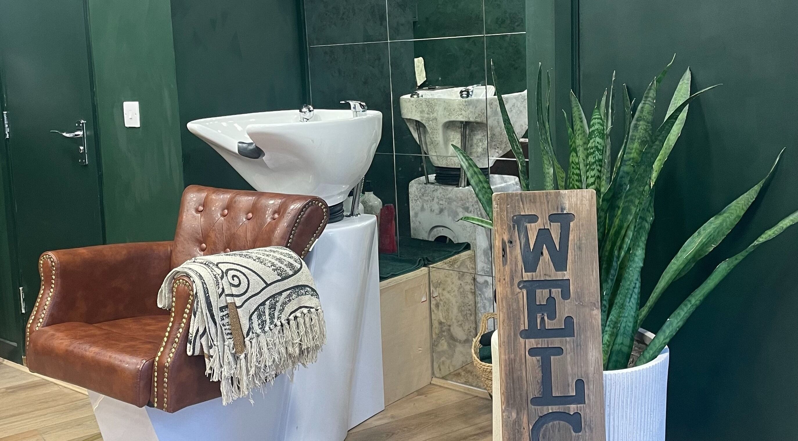 Inviting salon space at Koko - Emma, Cirencester, England, GB with elegant chair and lush greenery.