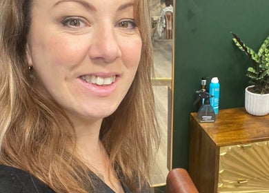 Friendly staff member at Koko - Emma, Cirencester, England, GB with a welcoming smile, next to stylish decor.