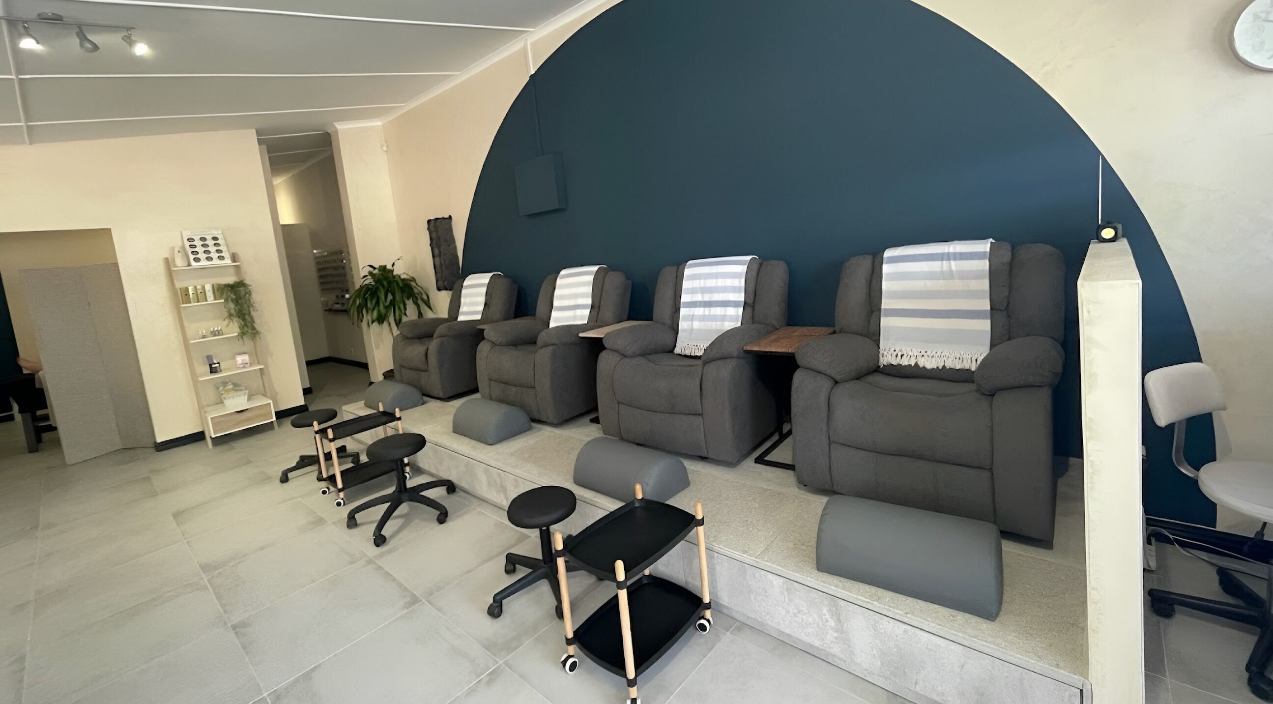 Relaxing seating area at Kirby & Teen Nail Boutique, Cape Town, Western Cape, ZA. Cozy chairs against a sleek wall.