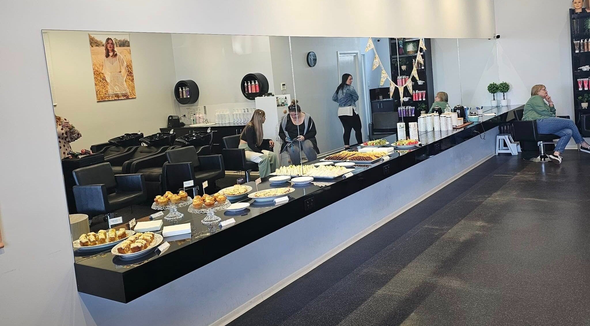 Interior of Astrid Salt Hair And Beauty Design in Budgewoi, featuring a spread of food and stylish seating areas.