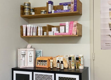 Produits de beauté chez Magali Pires, Nieul-sur-mer, Nouvelle-aquitaine, FR. Étagères en bois avec cosmétiques.