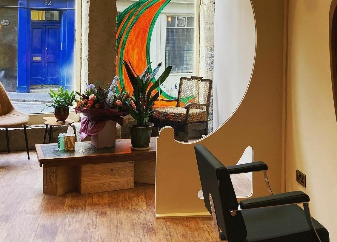Stylish interior of Outline Hair in Edinburgh, Scotland, GB with a modern chair and plants.