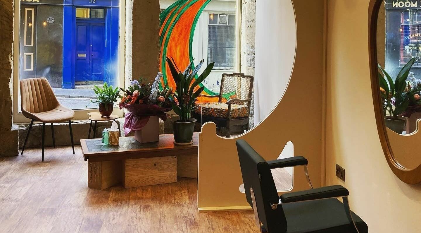 Stylish interior of Outline Hair in Edinburgh, Scotland, GB with a modern chair and plants.