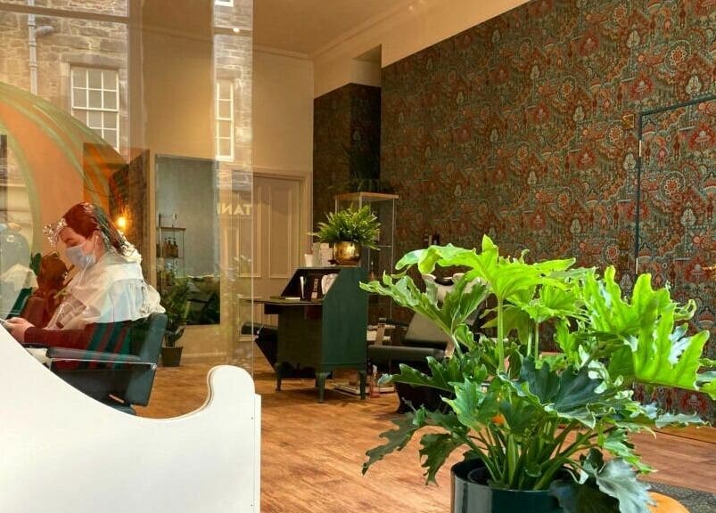Interior of Outline Hair, Edinburgh, Scotland, GB with stylish decor and client in hair treatment session.