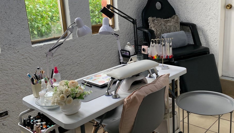 Mesa de manicura moderna en Monzu Nail Studio, Irapuato, Guanajuato, MX, con herramientas y decoraciones.