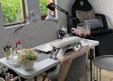 Mesa de manicura moderna en Monzu Nail Studio, Irapuato, Guanajuato, MX, con herramientas y decoraciones.