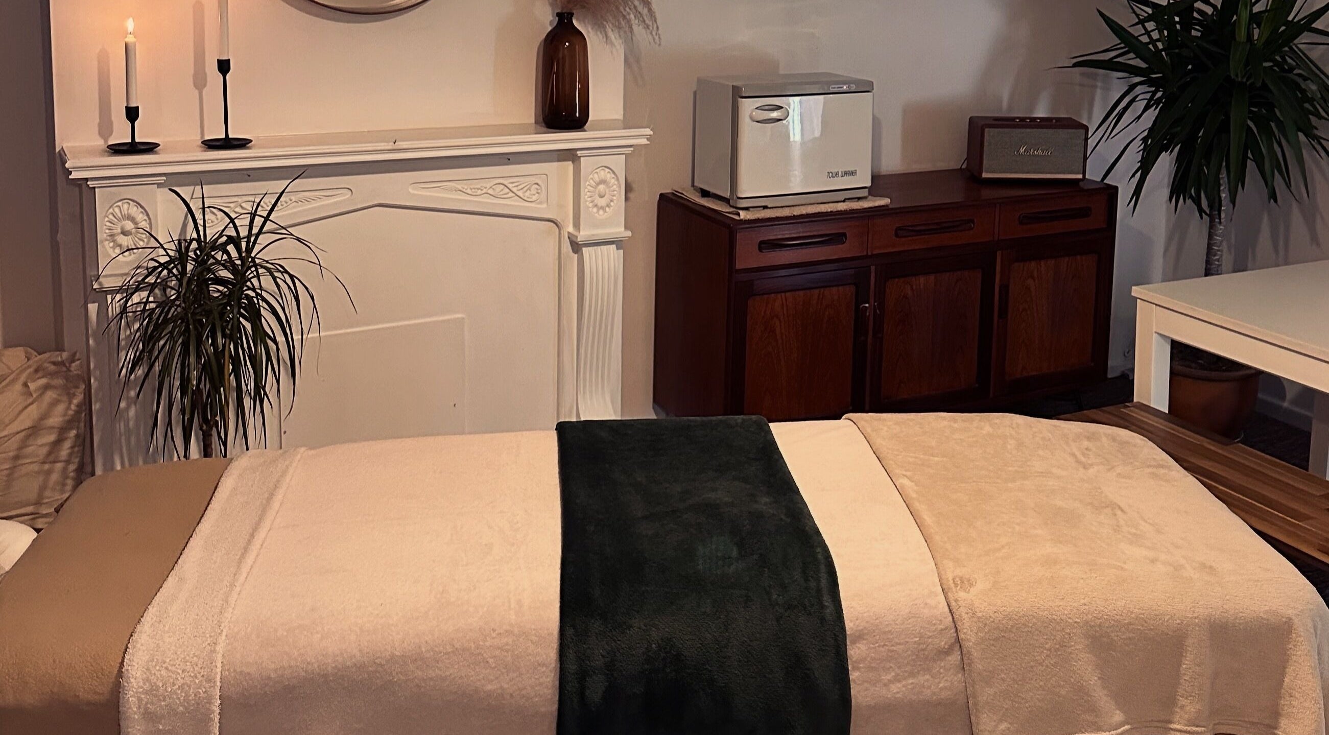 Tranquil massage room at Ruska, Poole, England, GB featuring plush towels and soothing decor.