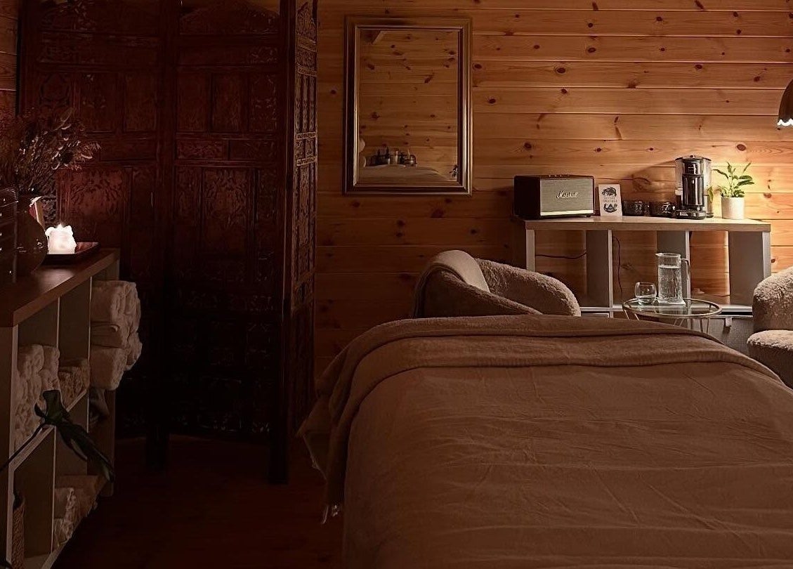 Rustic spa treatment room at Ruska, Poole, England, GB with warm lighting and comfortable seating.