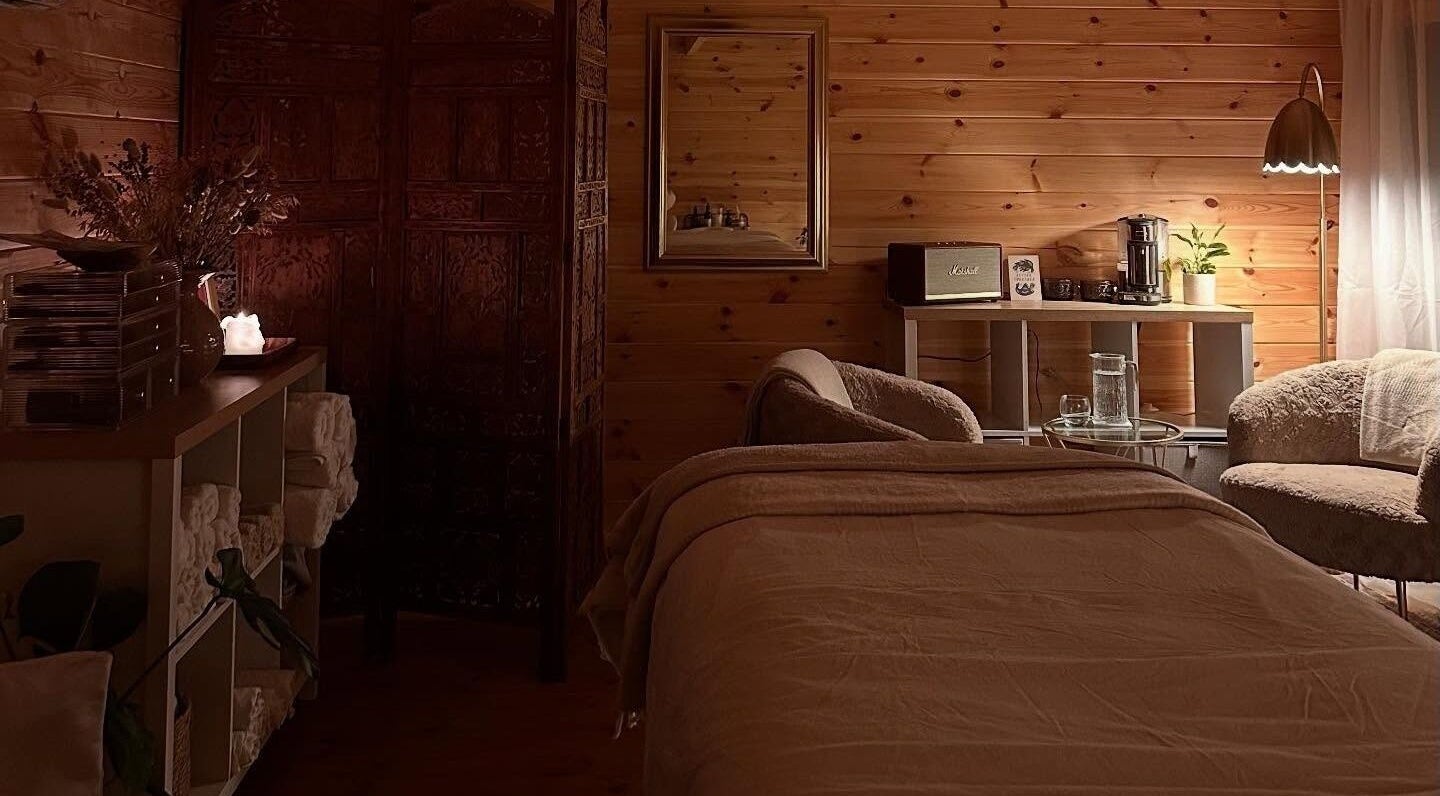 Rustic spa treatment room at Ruska, Poole, England, GB with warm lighting and comfortable seating.