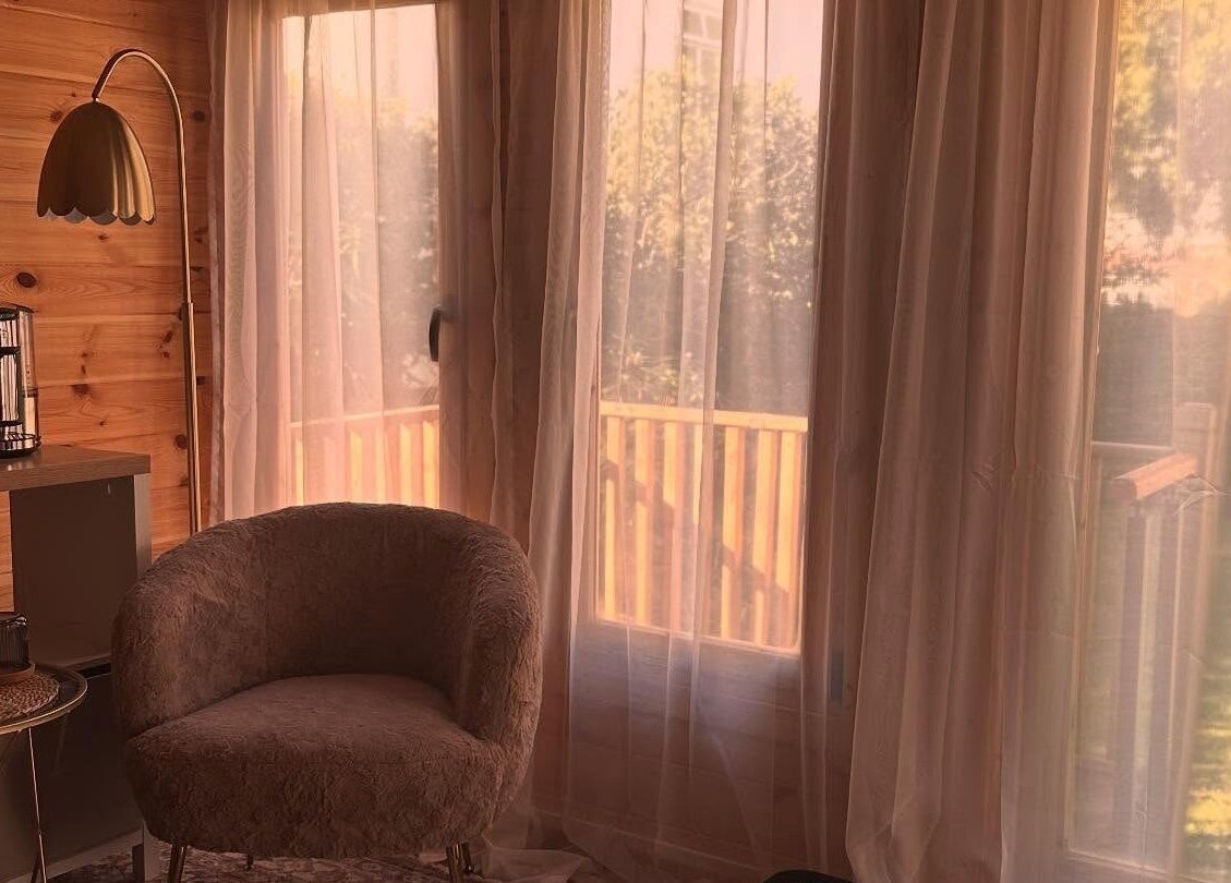 Relaxing corner in Ruska, Poole, England, GB with chairs, curtains, and warm lighting.