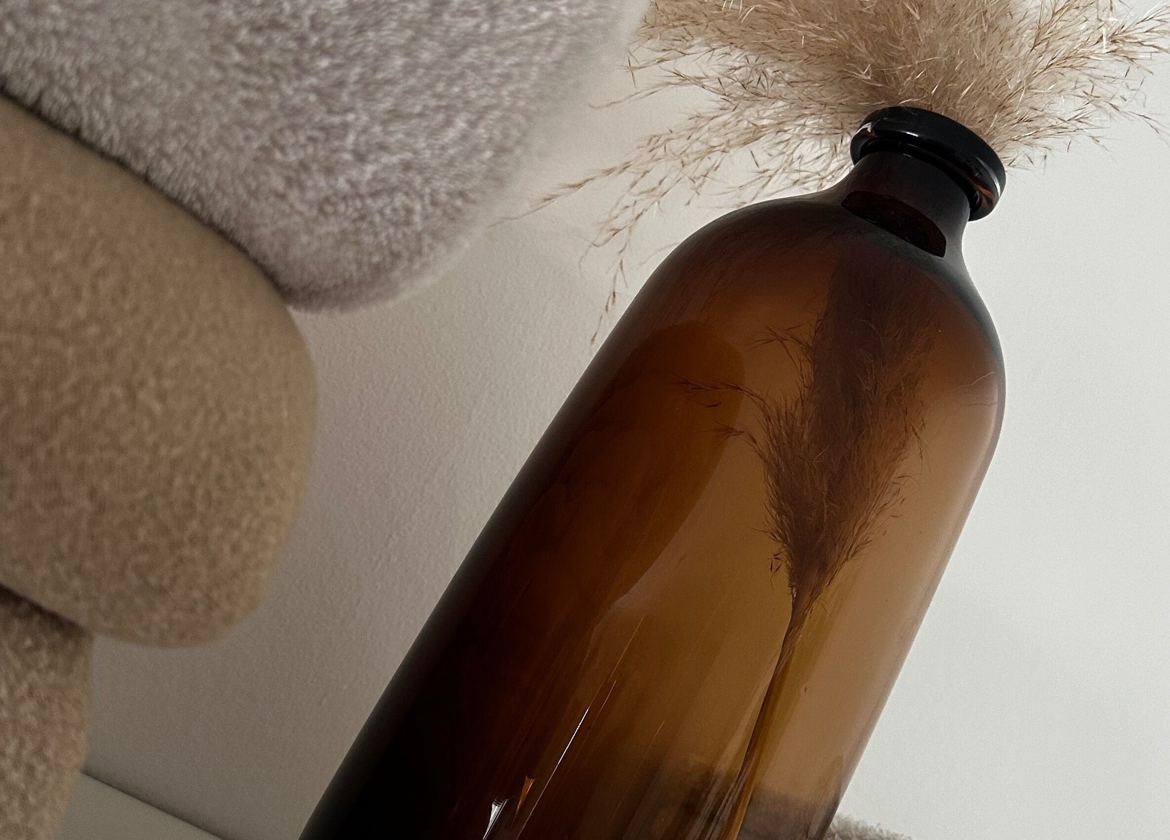 Amber glass vase with pampas at Ruska, Poole, England, GB. Perfect decor for wellness ambiance.