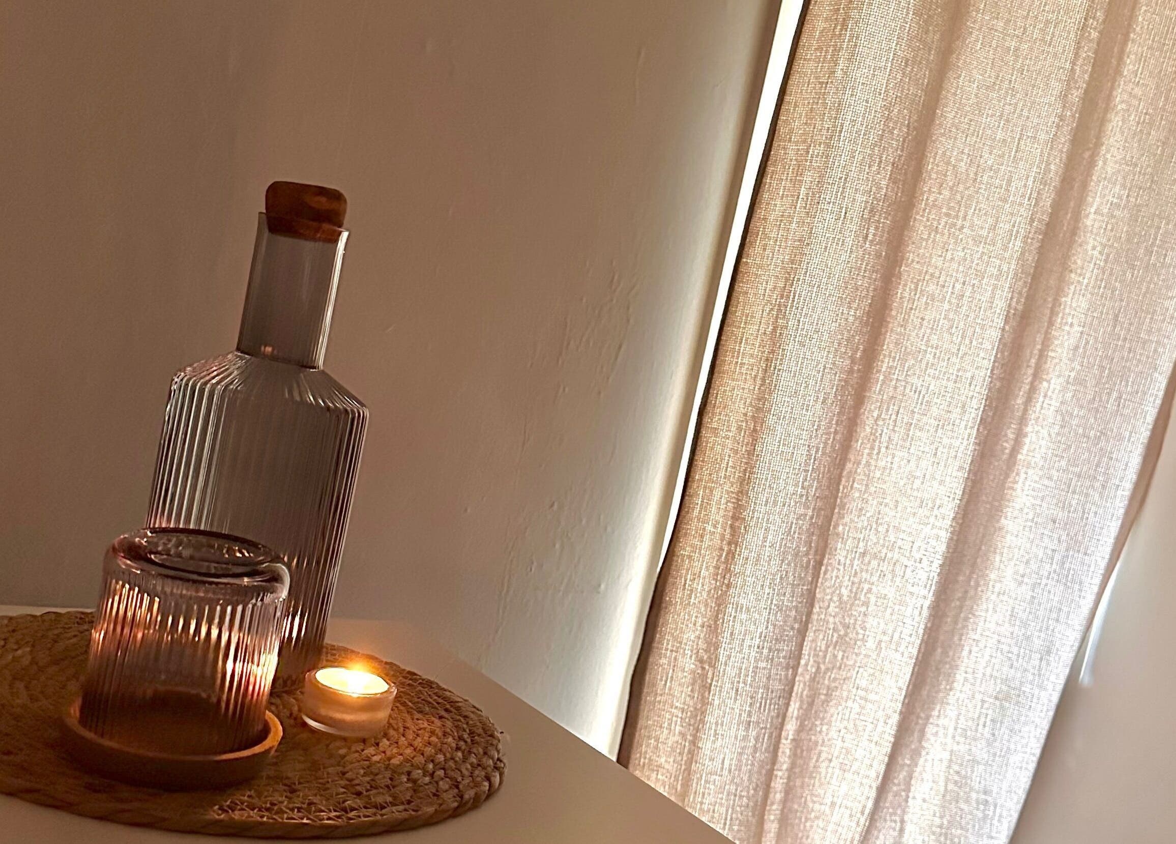 Candlelit ambiance at Ruska, Poole, England, GB. A serene glass bottle and candle set the mood.