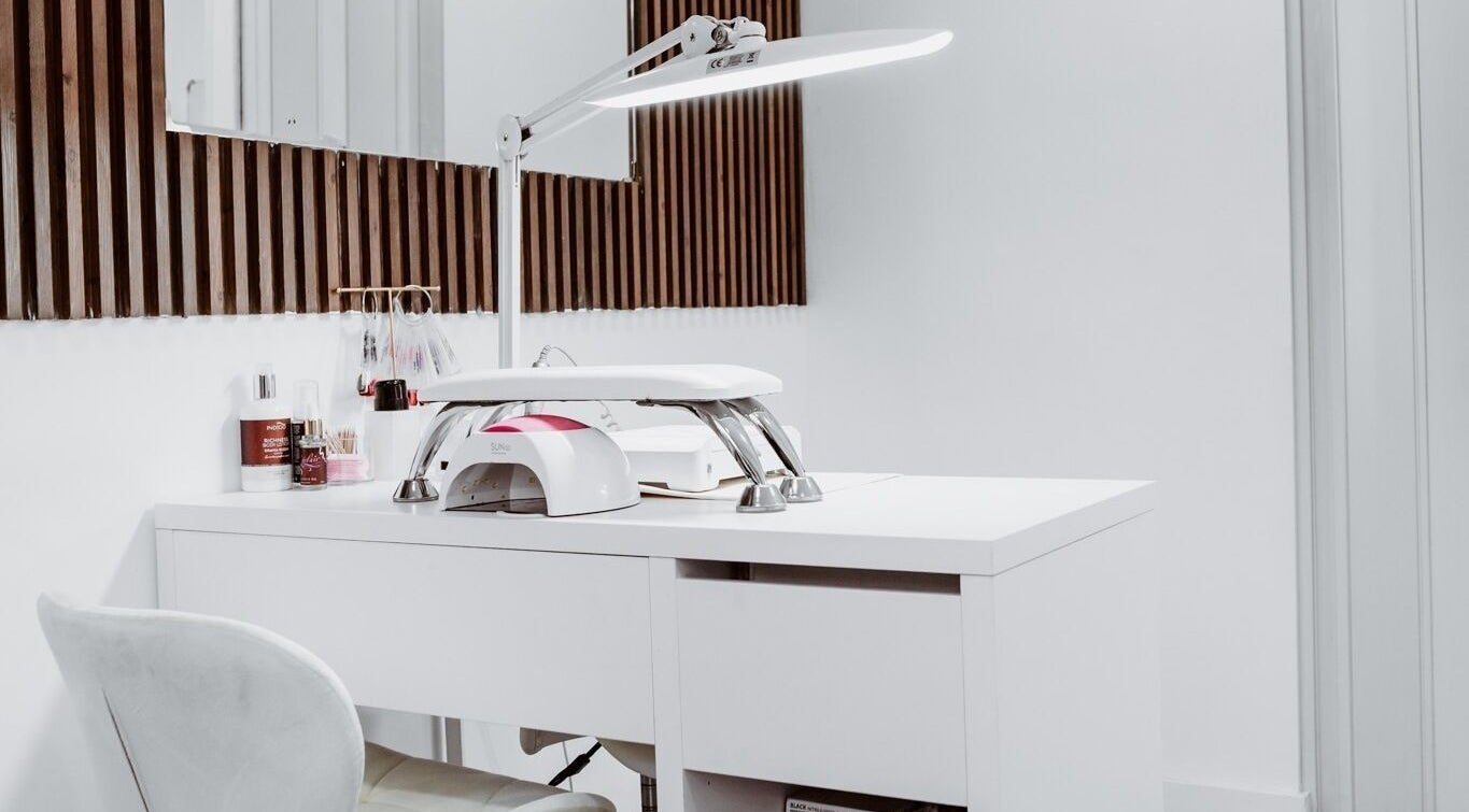 Modern manicure station at Just For You in Naxxar, MT, featuring sleek white design and nail care essentials.