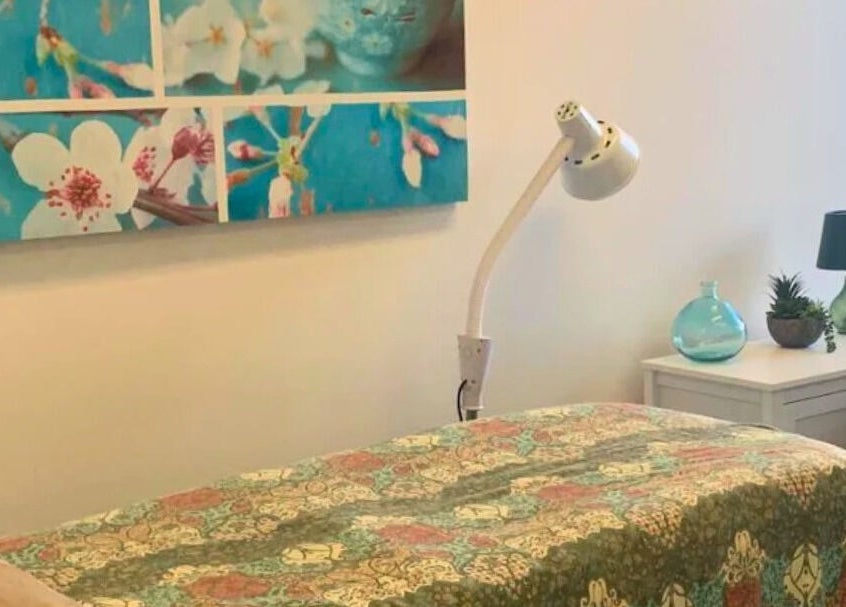 Therapy room at Golden Crown Healing (Sunshine Coast), Coolum Beach with floral decor and soft lighting.