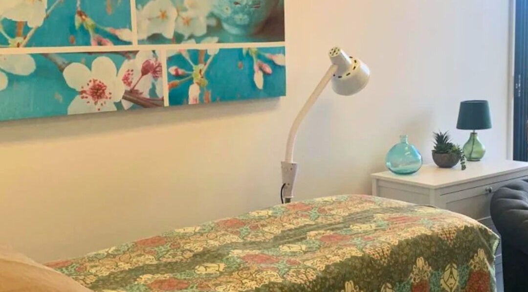 Therapy room at Golden Crown Healing (Sunshine Coast), Coolum Beach with floral decor and soft lighting.