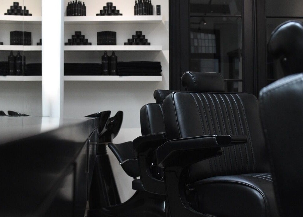 Modern black salon chairs at MENSPIRE Maastricht, Limburg, NL, showcasing luxury and comfort.