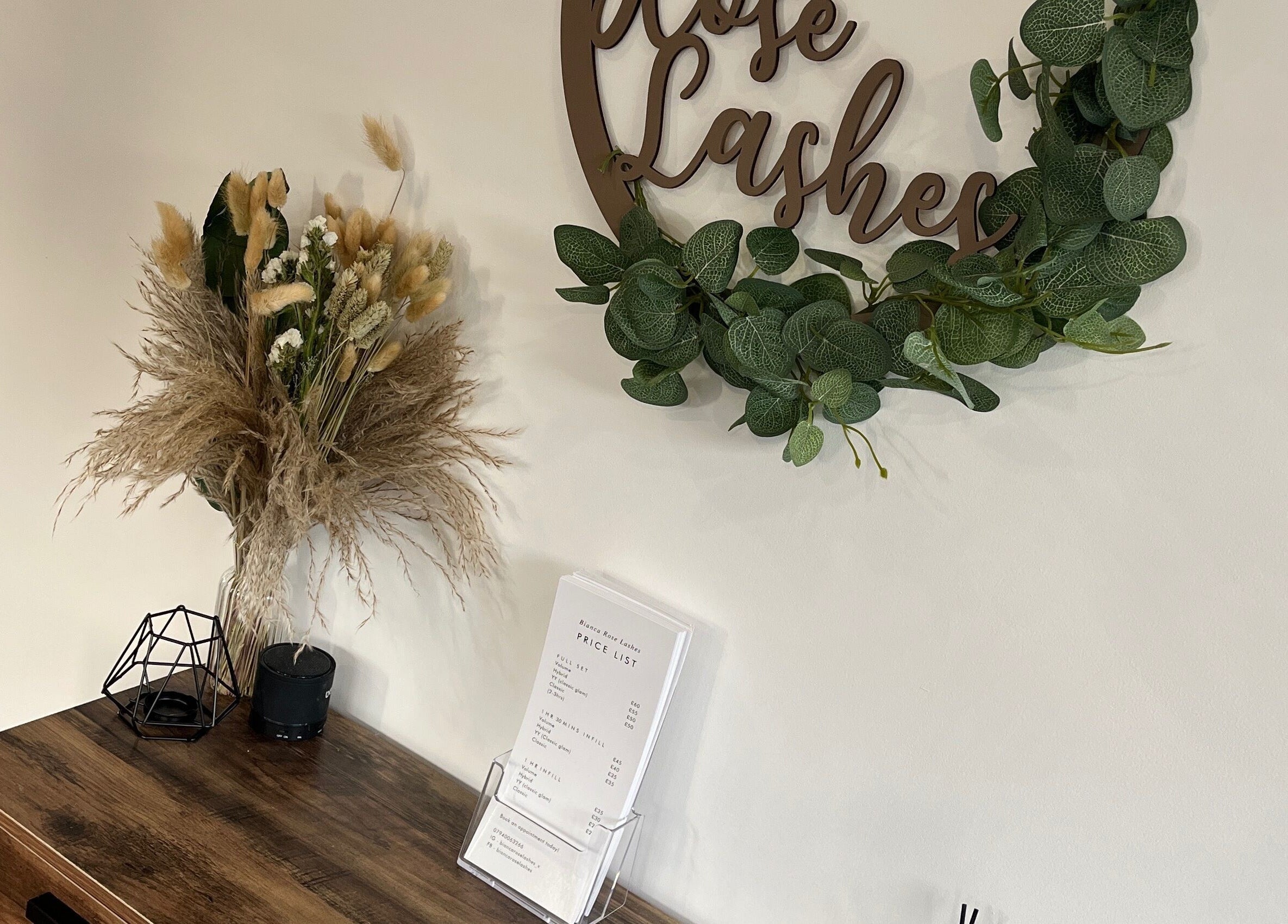 Elegant decor at Bianca Rose Lashes, Saint Blazey, England, with green wreath and dried floral arrangement.