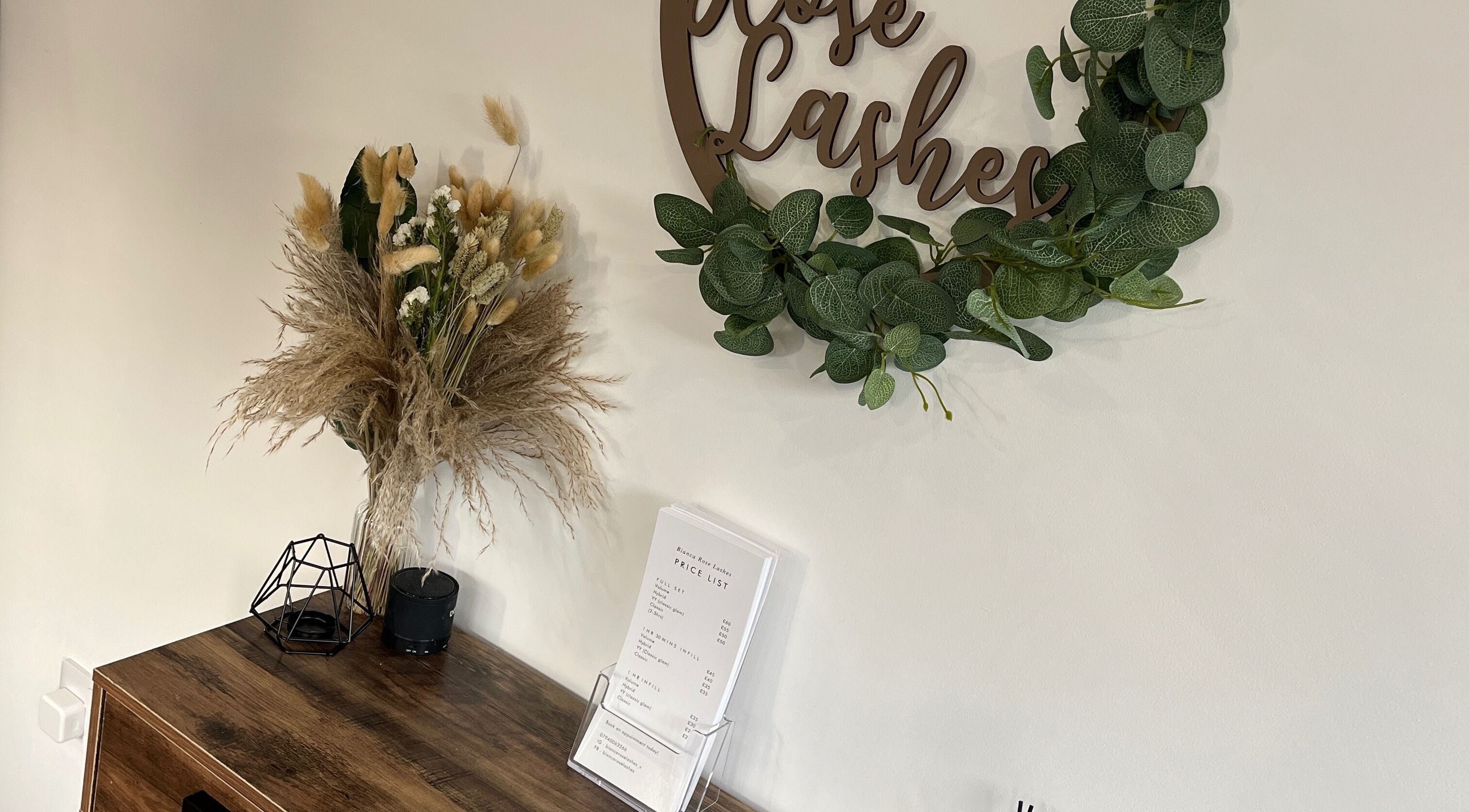 Elegant decor at Bianca Rose Lashes, Saint Blazey, England, with green wreath and dried floral arrangement.