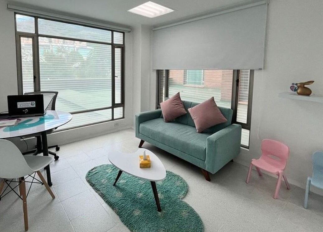 Sala acogedora en Fono-Care, Bogotá, Bogotá, CO, con sofá verde y mesa moderna.