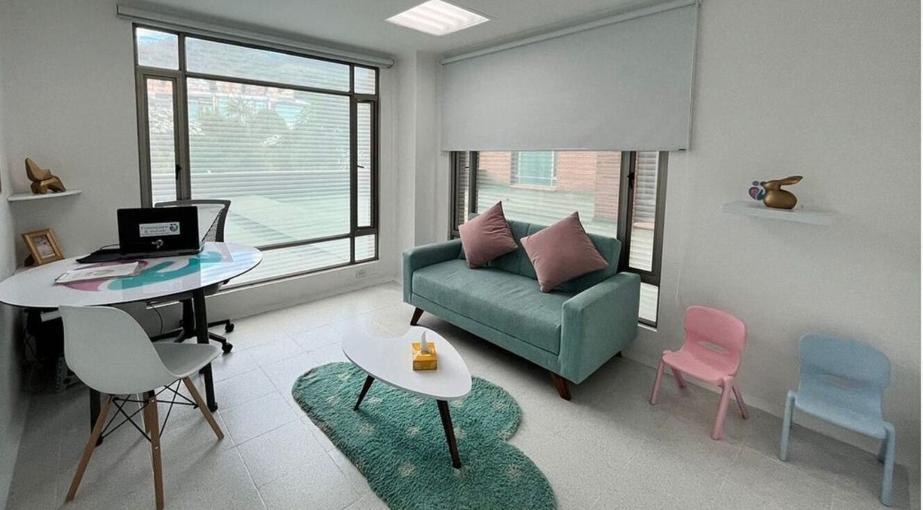 Sala acogedora en Fono-Care, Bogotá, Bogotá, CO, con sofá verde y mesa moderna.