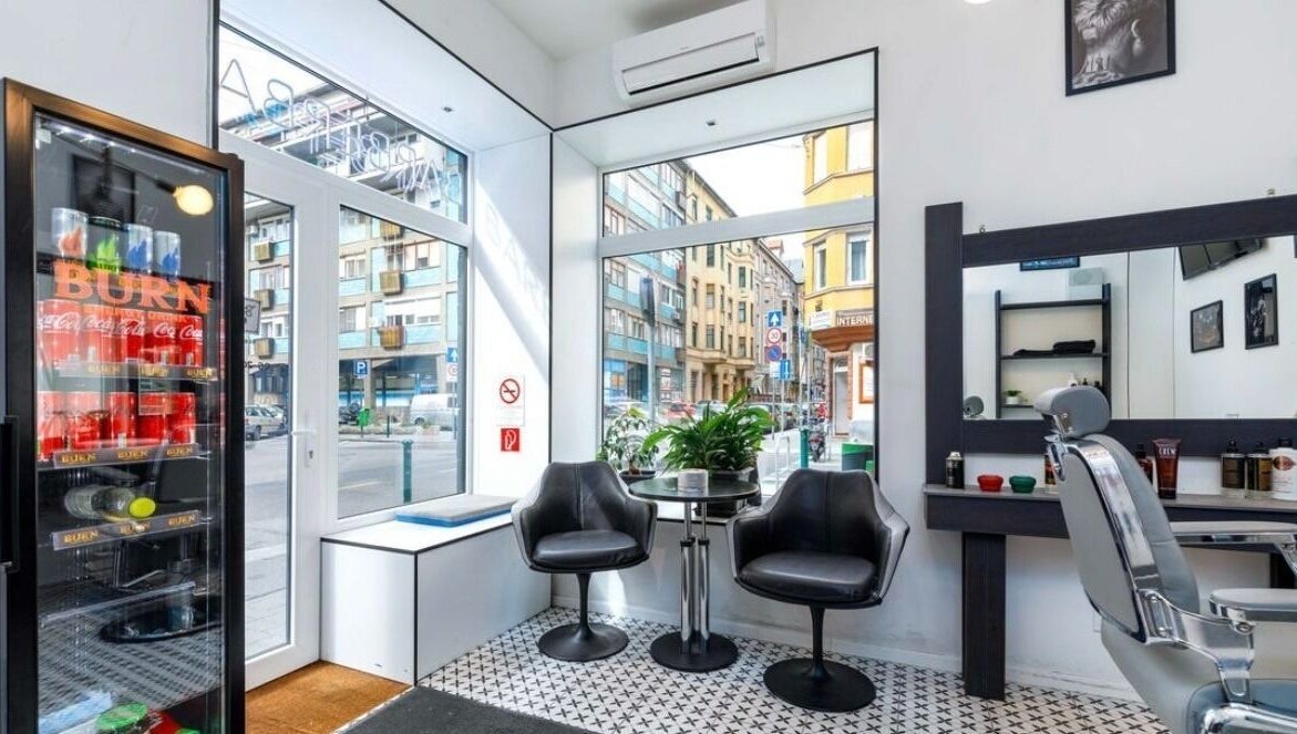 Belvárosi szalon ülősarok a BarberBar-ban, Budapest, Magyar, HU. Stílusos fekete székek és növények.