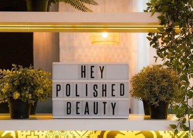 Polished Spa in Sharjah, AE: inviting display with plants and 'Hey Polished Beauty' sign.