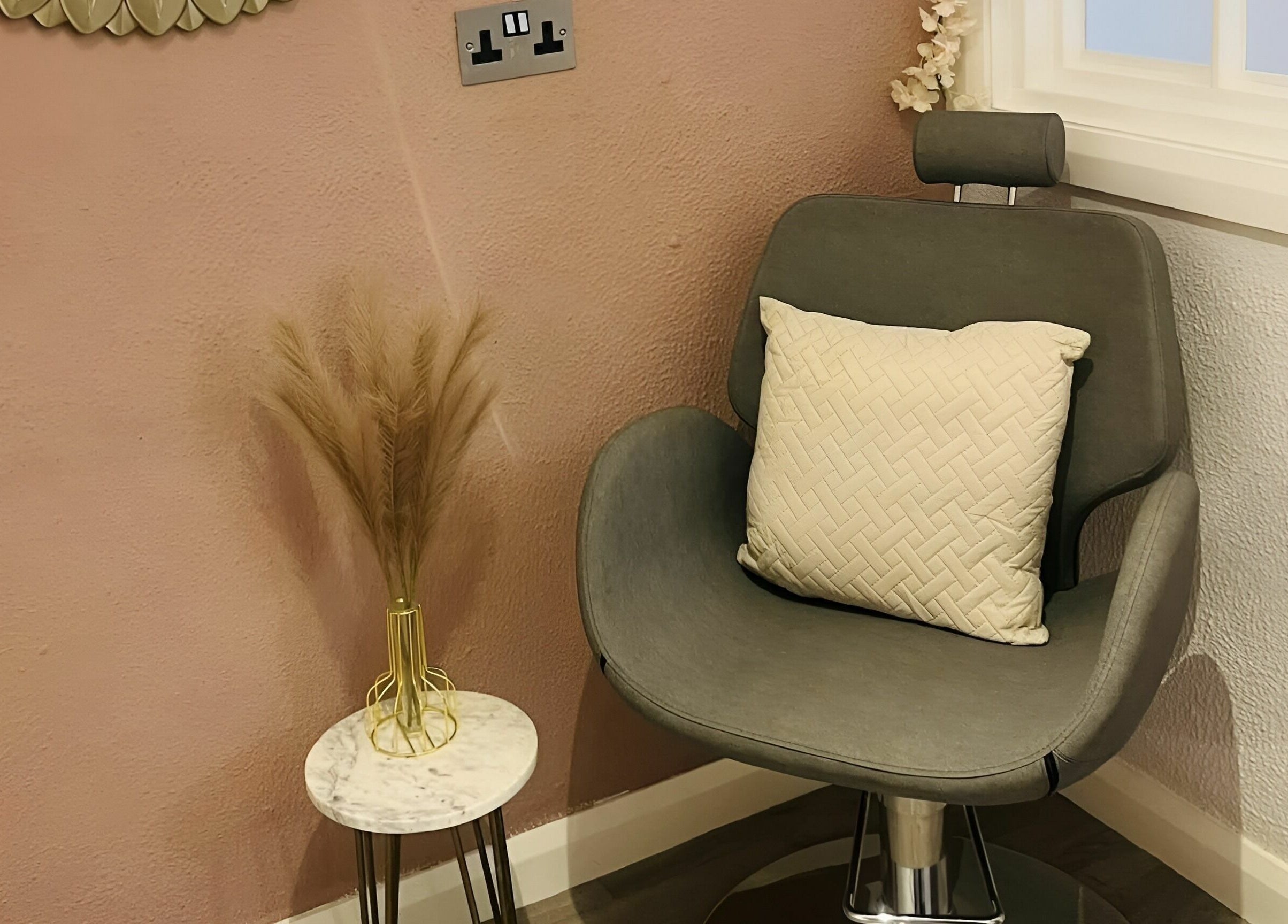Elegant seating area at Seaside Retreat, Peel, Peel, IM featuring a plush chair and vase on a marble table.