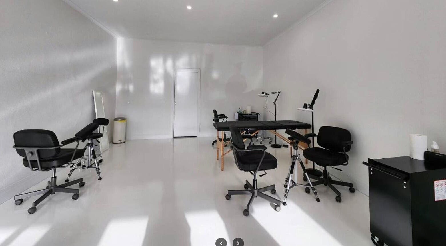 Modern tattoo studio at Inkfinity Tattoo, Carnegie, Victoria, AU with sleek black chairs and bright lighting.