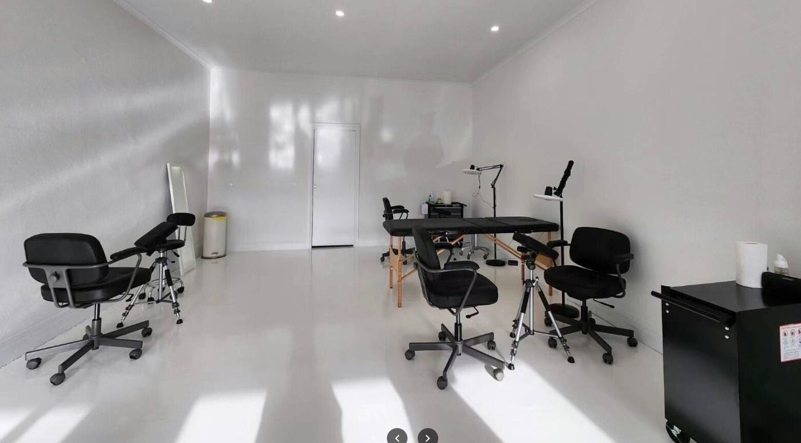 Modern tattoo studio at Inkfinity Tattoo, Carnegie, Victoria, AU with sleek black chairs and bright lighting.