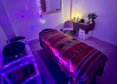 Cozy massage room with ambient lighting at The Massage Space, Winchester, England, GB, featuring a comfortable table.