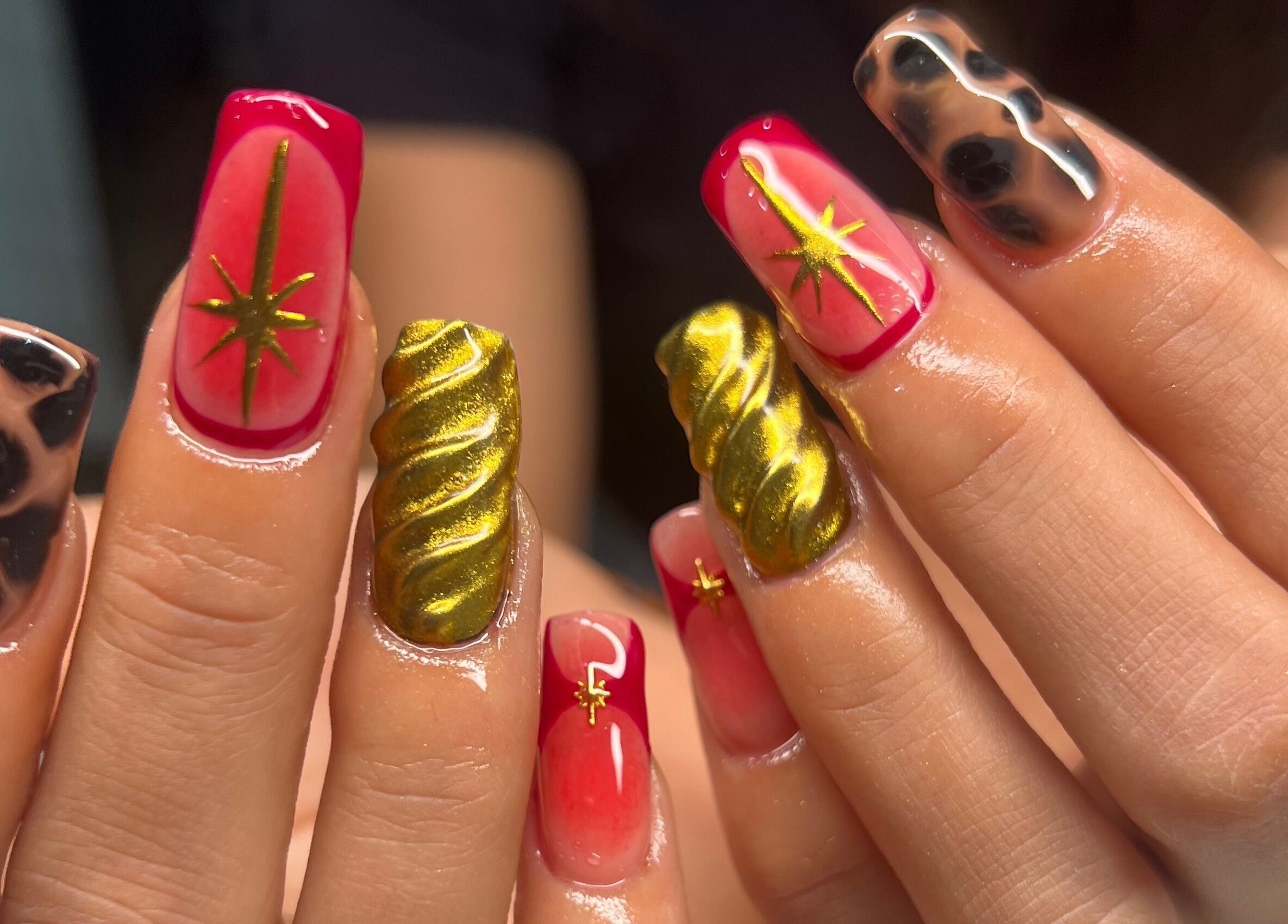 Vibrant nail art at Eve Studio in Tuggerah, New South Wales, AU, showcasing intricate gold and leopard patterns.