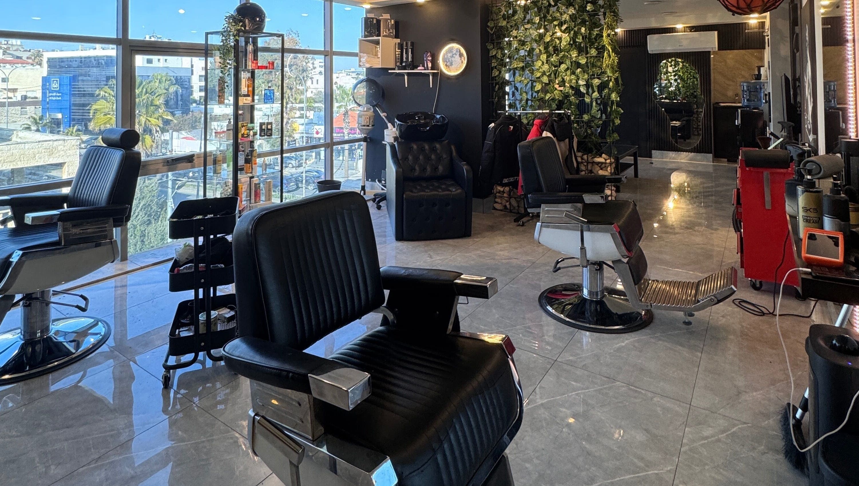 Modern barbershop at The Dala, Amman, Amman Governorate, JO, with stylish chairs and sleek decor.