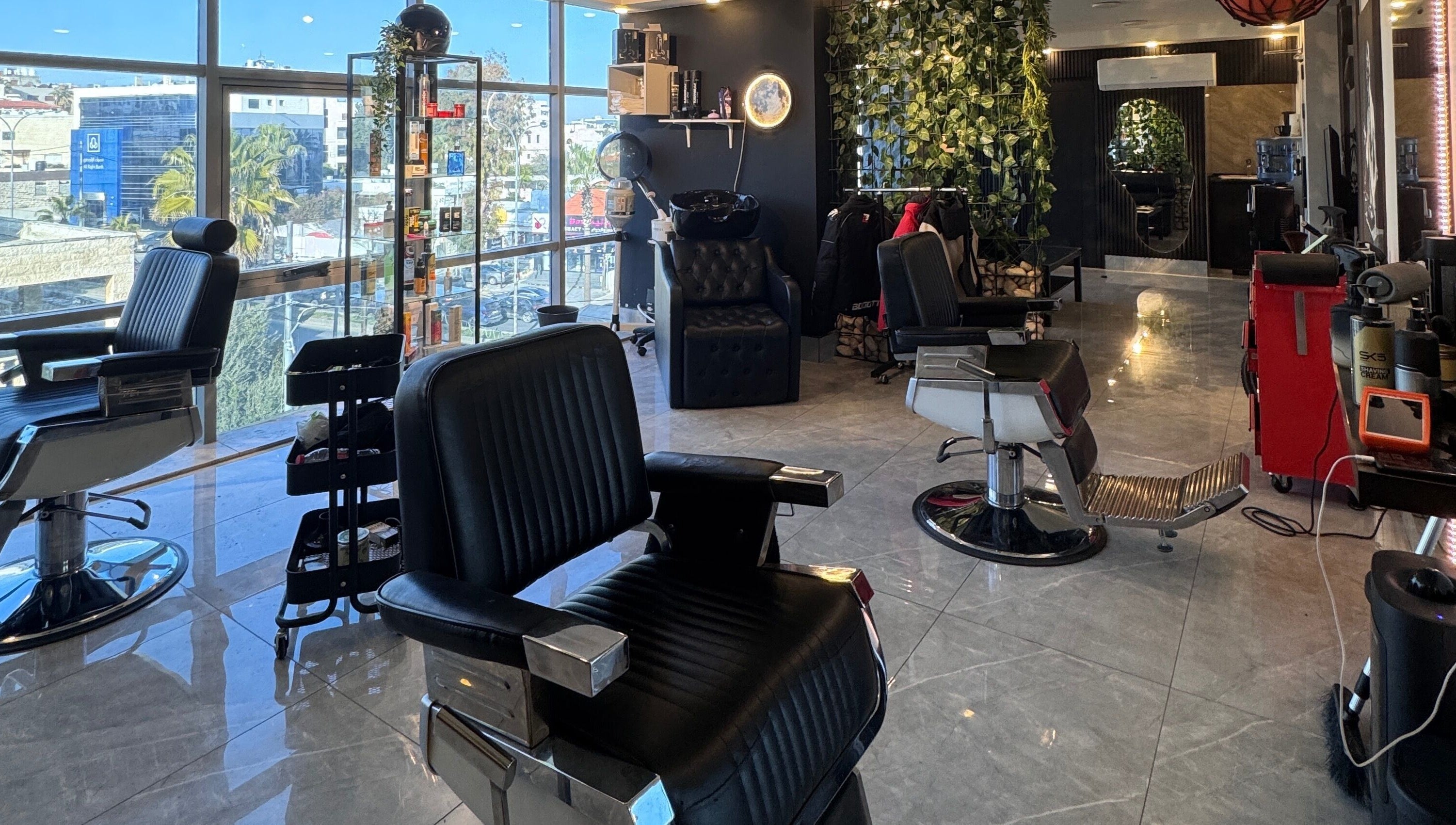 Modern barbershop at The Dala, Amman, Amman Governorate, JO, with stylish chairs and sleek decor.
